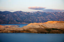 Ostrov Pag, v pozadí Velebit, Chorvatsko