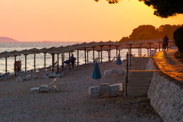 Primošten - oblázková pláž u promenády v zátoce Mala Raduča, Šibenická riviéra, Chorvatsko