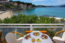 Lumbarda - pohled z restaurace na písečnou pláž Tatinja, ostrov Korčula, Chorvatsko