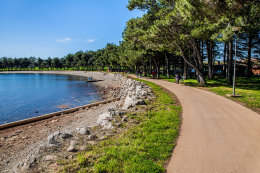 Novigrad - oblázková pláž s promenádou, Istrie, Chorvatsko