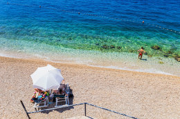 Letovisko Igrane - veřejná oblázková pláž pod hotelem (lehátka patří hotelu), Makarská riviéra, Chorvatsko