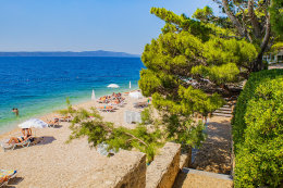 Letovisko Igrane - veřejná oblázková pláž pod hotelem (lehátka patří hotelu), Makarská riviéra, Chorvatsko