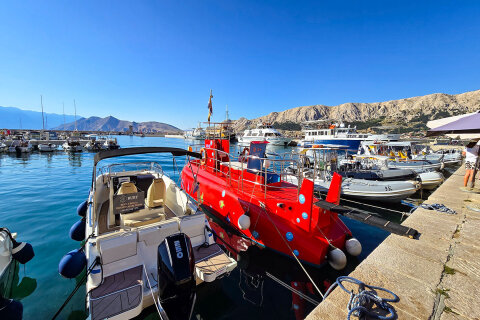 Baška - promenáda s kiosky nabízejícími lodní výlety a lodní taxi, ostrov Krk, Chorvatsko