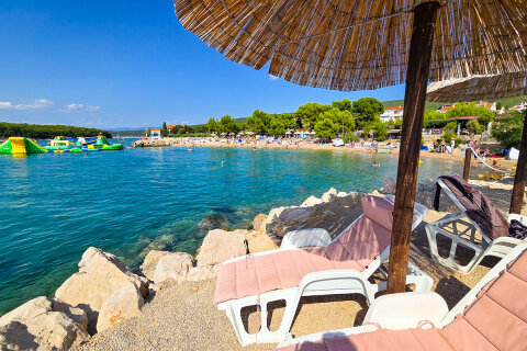 Punat - půjčovna lehátek a slunečníků u pláže, ostrov Krk, Chorvatsko